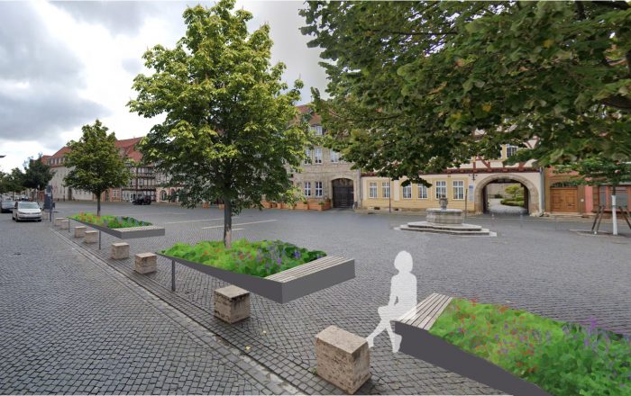 Öffentlicher Platz mit Bänken und bepflanzten Beeten in einer Stadt.