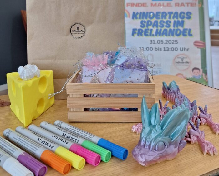 Braune Papiertüte mit bunten Bastelmaterialien und einem kleinen Holzkorb auf einem Tisch.